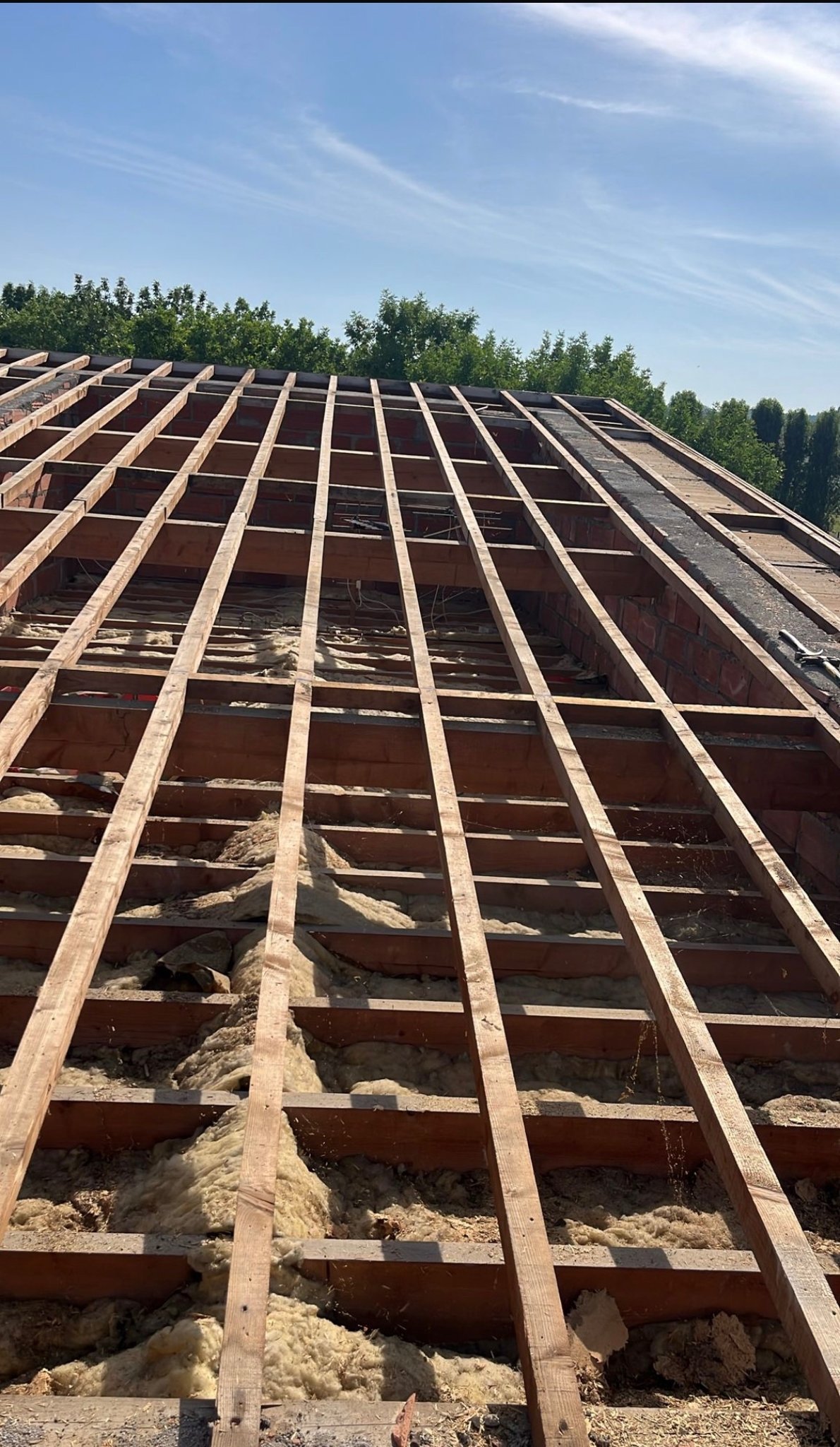 Charpente mise à nu avant rénovation, chantier mené par Les Couvreurs Belges